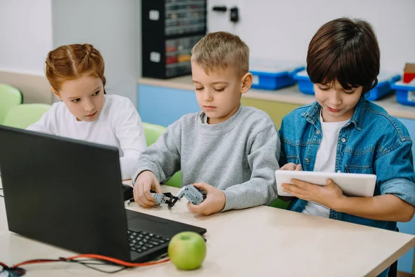 Groupe d'enfants travaillant ensemble pour construire robot, concept d'éducation tige — Photo de stock