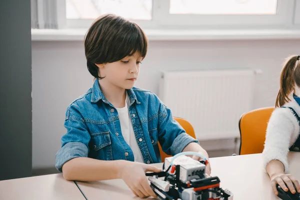 Criança pequena séria fazendo robô diy, conceito de educação de tronco — Fotografia de Stock