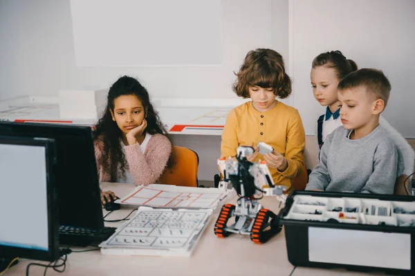 Centrado adolescente niños la construcción de bricolaje robot en clase de maquinaria - foto de stock