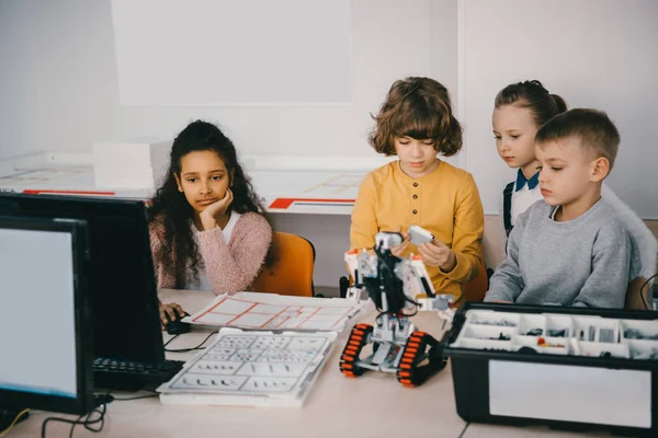 Focused teen kids constructing diy robot at machinery class — Stock Photo