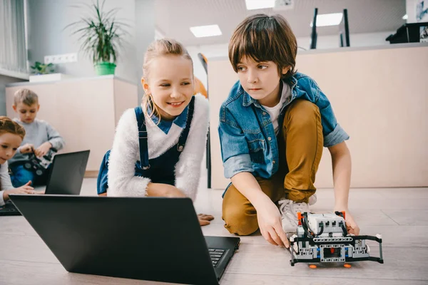 Kids programming robot on floor at machinery class — Stock Photo