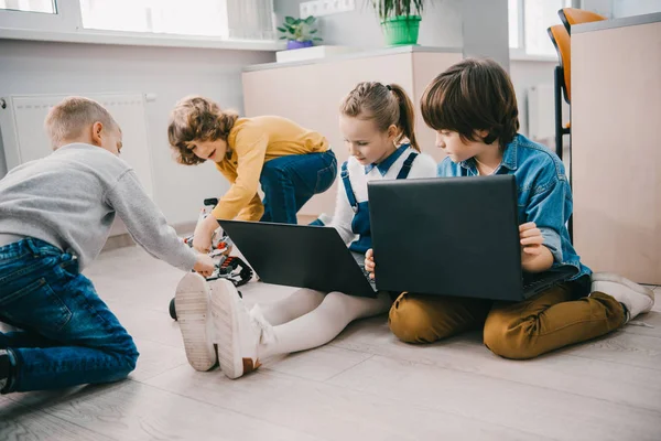 Happy kids working with laptops on floor, stem education concept — Stock Photo