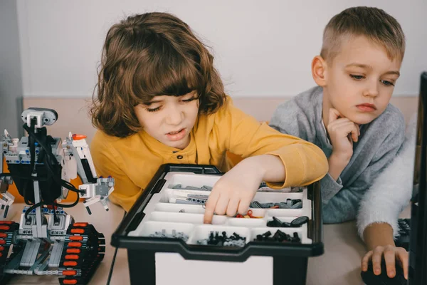 Concentrated kids constructing diy robot, stem education concept — Stock Photo