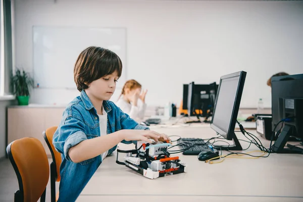 Adolescente niño programación bricolaje robot en clase de maquinaria - foto de stock