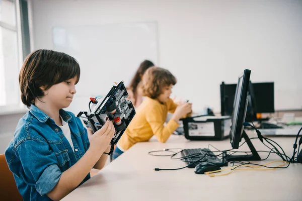 Confused teen kid with diy robot at machinery class — Stock Photo