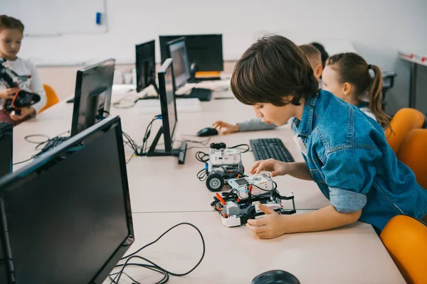 Concentrated teen child constructing robot at class, stem education concept — Stock Photo