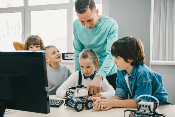 Teacher working with teen students on diy robot on stem education class — Stock Photo