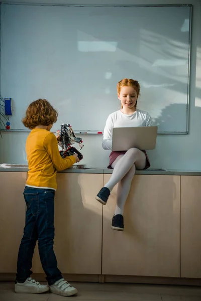 Adorable little schoolkids working together on machinery class — Stock Photo