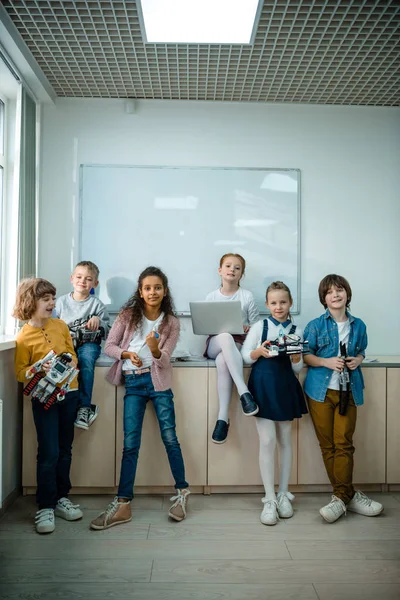 Group of kids posing together with laptop and robots on stem education class — Stock Photo