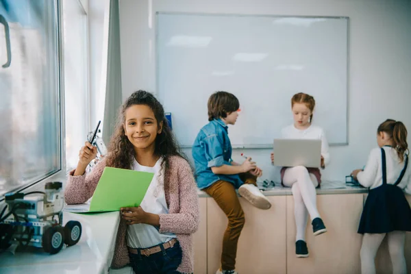 Grupo multiétnico de niños pequeños que trabajan juntos en la clase de maquinaria - foto de stock