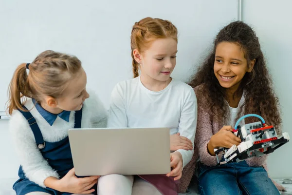 Groupe d'écolières heureuses travaillant avec ordinateur portable ensemble sur la classe d'éducation tige — Photo de stock