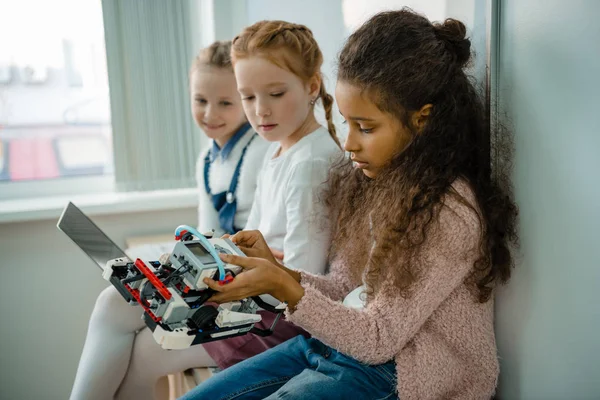 Gruppo di scolarette che lavorano insieme con il computer portatile sulla classe di educazione staminale — Foto stock