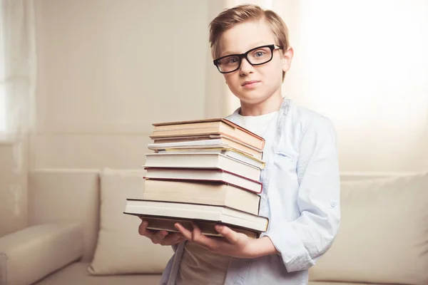 Мальчик держит груду книг — стоковое фото