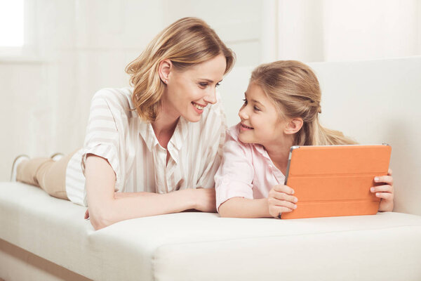 mother and daughter using digital tablet
