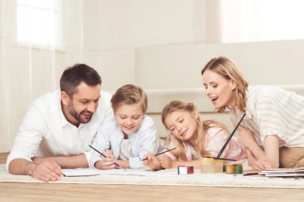 Ευτυχισμένη οικογένεια ζωγραφίζει εικόνες στο σπίτι — Φωτογραφία Αρχείου