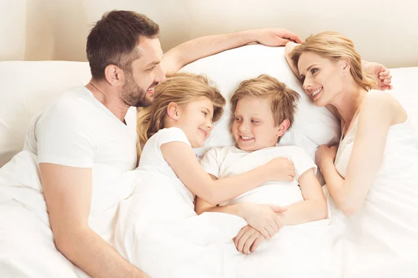 Família caucasiana feliz deitada na cama — Fotografia de Stock