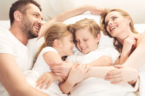 Ευτυχισμένη οικογένεια Καυκάσιος ξαπλωμένη στο κρεβάτι — Φωτογραφία Αρχείου