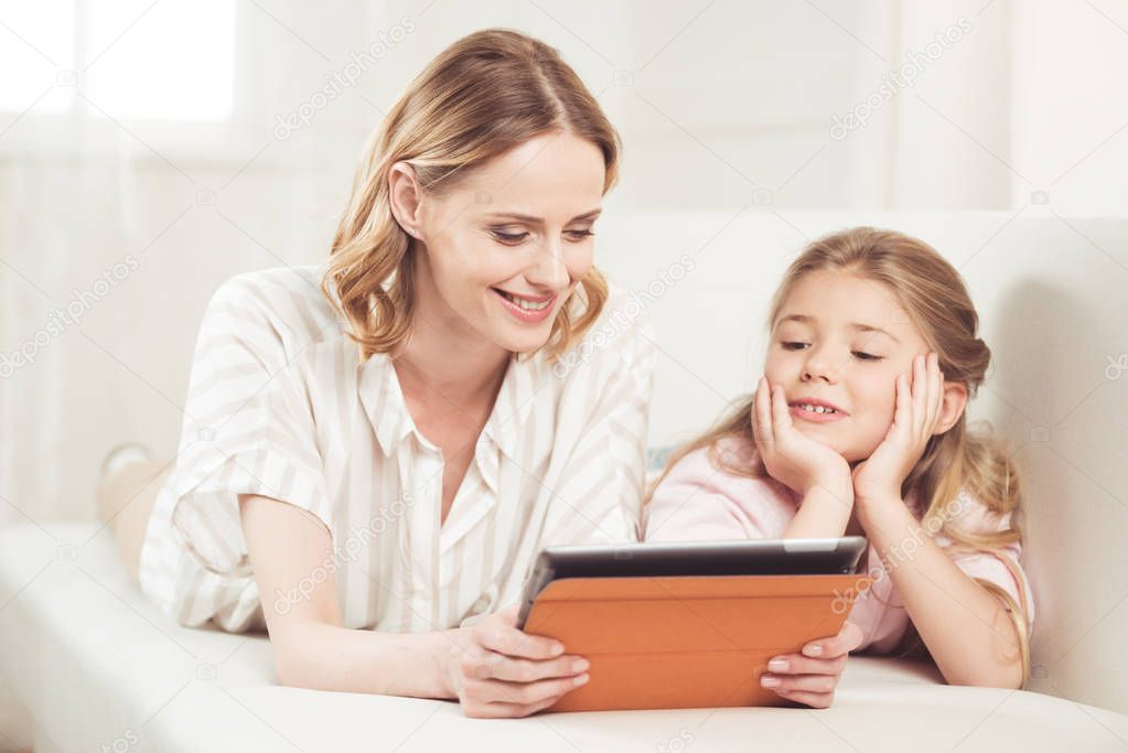 mother and daughter using digital tablet