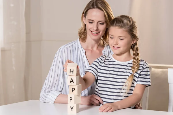 Girl and her mother using wooden cubes — Stock Photo, Image