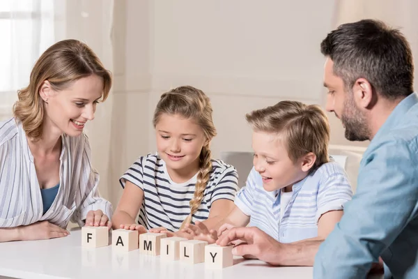 Leende familjen sittande vid bord — Stockfoto