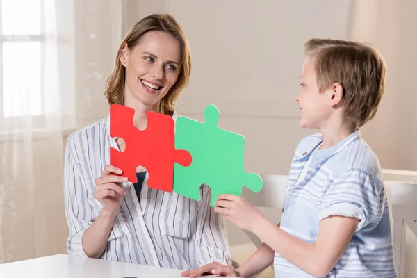 Мать с сыном держат головоломку — стоковое фото