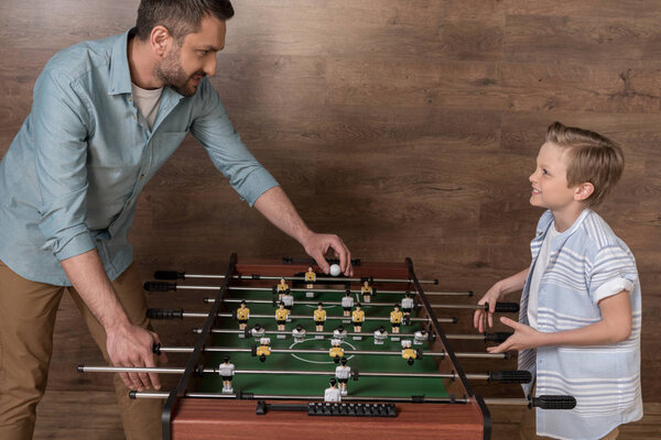 boy playing foosball with father