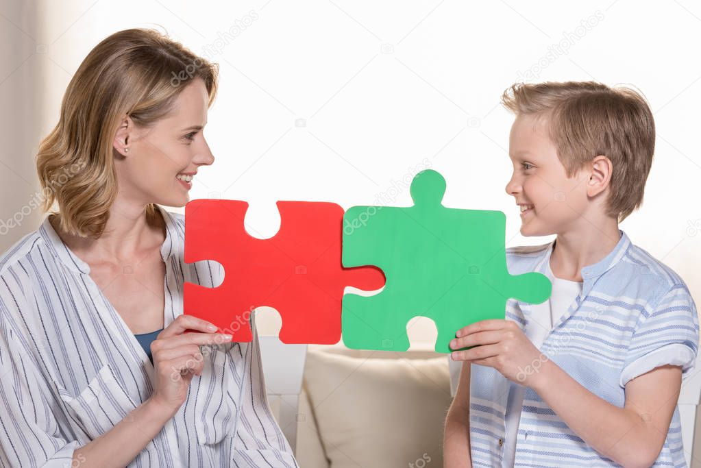 Mother with son holding puzzle