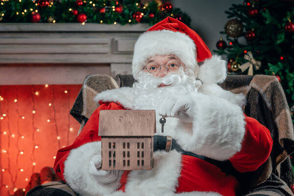 Санта с моделью дома и ключом
