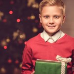 Niño sonriente con regalo de Navidad