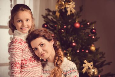 Anne ve kızı Noel arifesinde gülümseyen