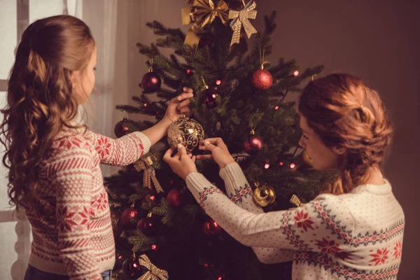 Mor och dotter dekorera julgran — Stockfoto