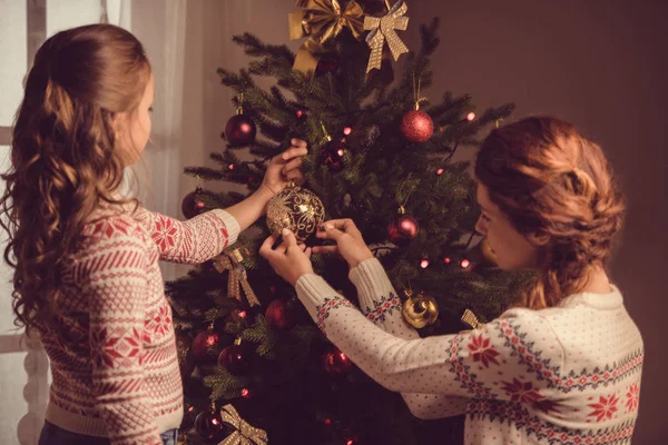Madre e figlia che decorano l'albero di Natale Foto Stock Royalty Free