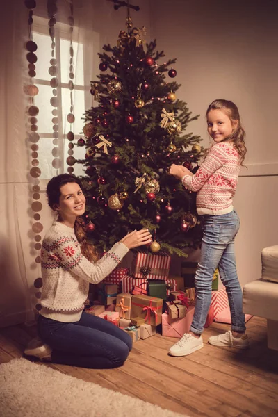 Ibu dan anak menghias pohon Natal Stok Foto
