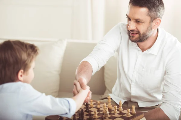 Padre e hijo estrechando las manos - foto de stock