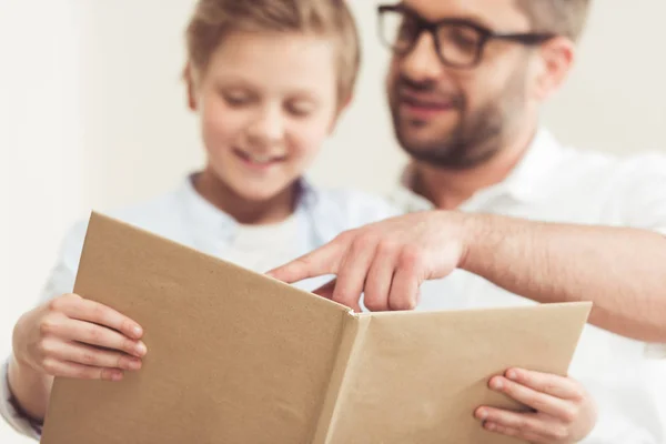 Hijo con padre libro de lectura - foto de stock