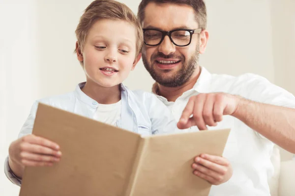 Hijo con padre libro de lectura - foto de stock