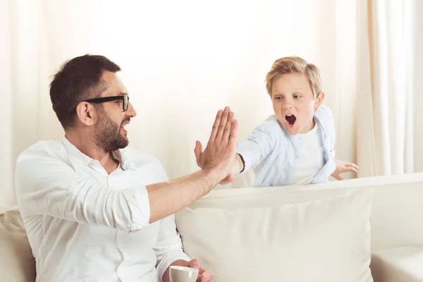 Padre dando choca cinco a hijo - foto de stock