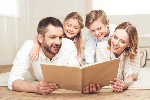 Livre de lecture familial souriant — Photo de stock