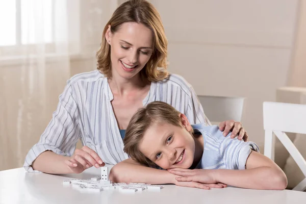 Mère et fils avec des morceaux de domino — Photo de stock