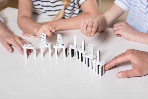 Famille jouer avec des morceaux domino — Photo de stock