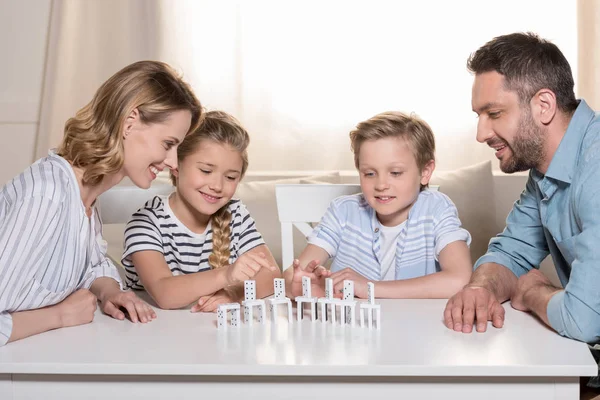 Famille jouer avec des morceaux domino — Photo de stock