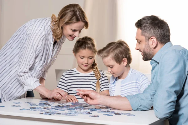 Семья играет с головоломкой — стоковое фото
