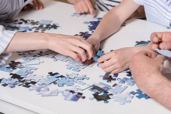Family playing with puzzle — Stock Photo