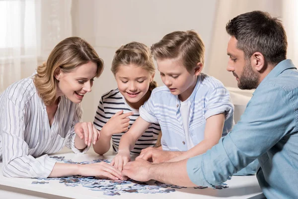 Family playing with puzzle — Stock Photo