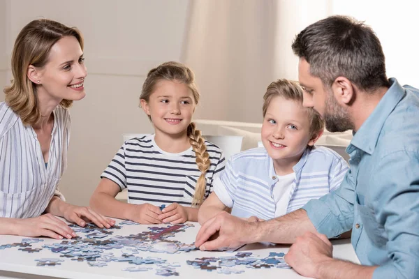 Family playing with puzzle — Stock Photo