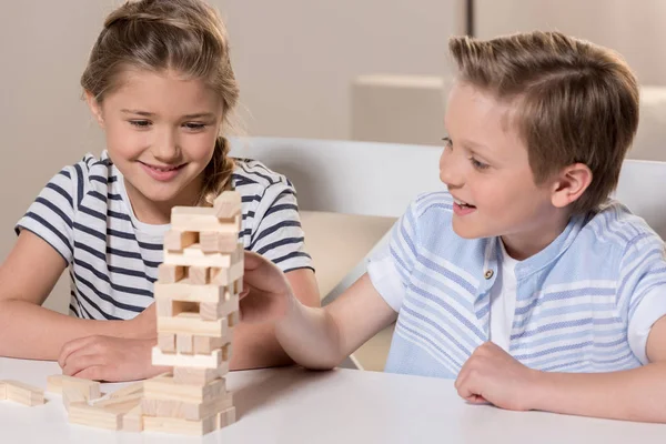 Frères et sœurs jouant au jeu Jenga — Photo de stock