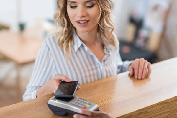 Paiement avec smartphone par femme — Photo de stock