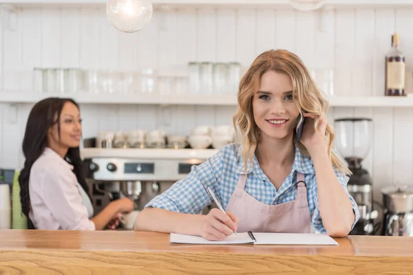 Waitress with smrtaphone at cafe — Stock Photo