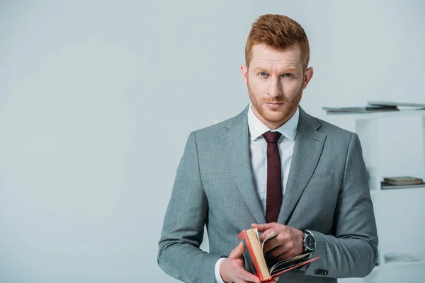 Hombre de negocios guapo con libro - foto de stock