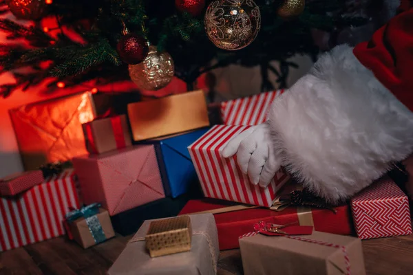 Santa con regalos bajo el árbol de Navidad - foto de stock